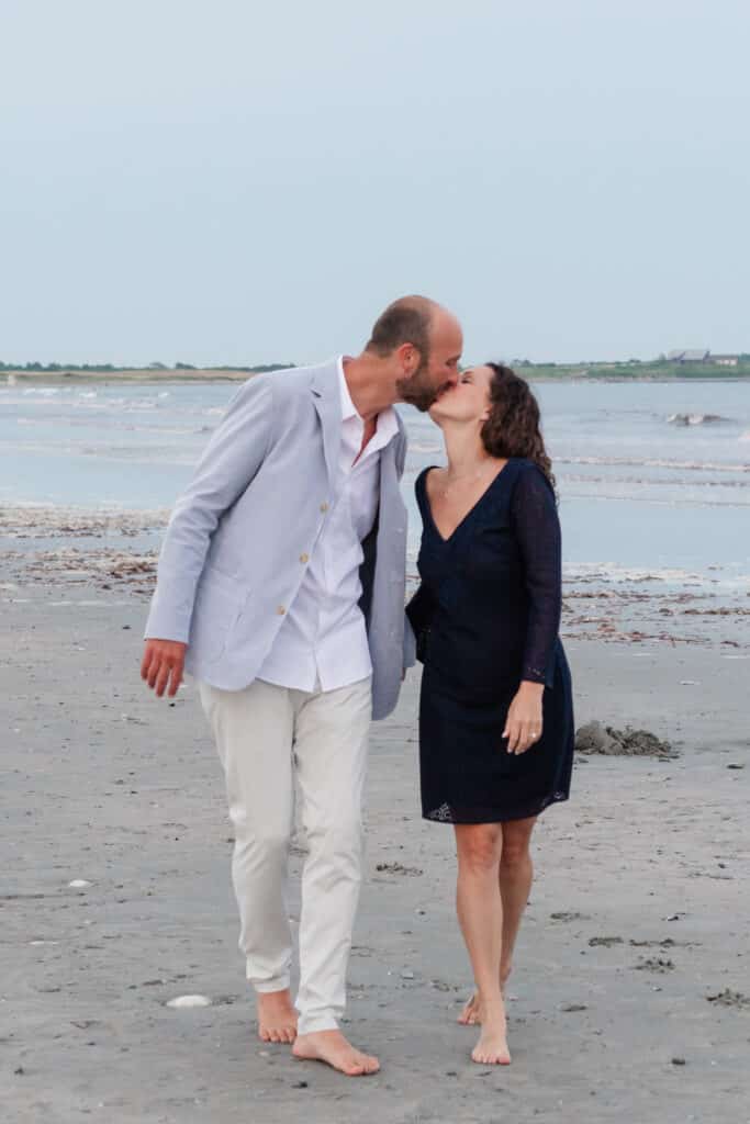 couple walks on middletown beach kissing