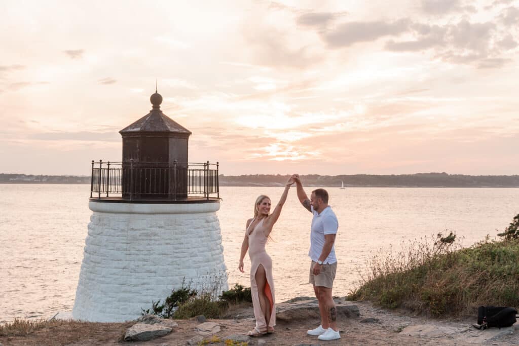 couple dances in front of a newport lighthouse