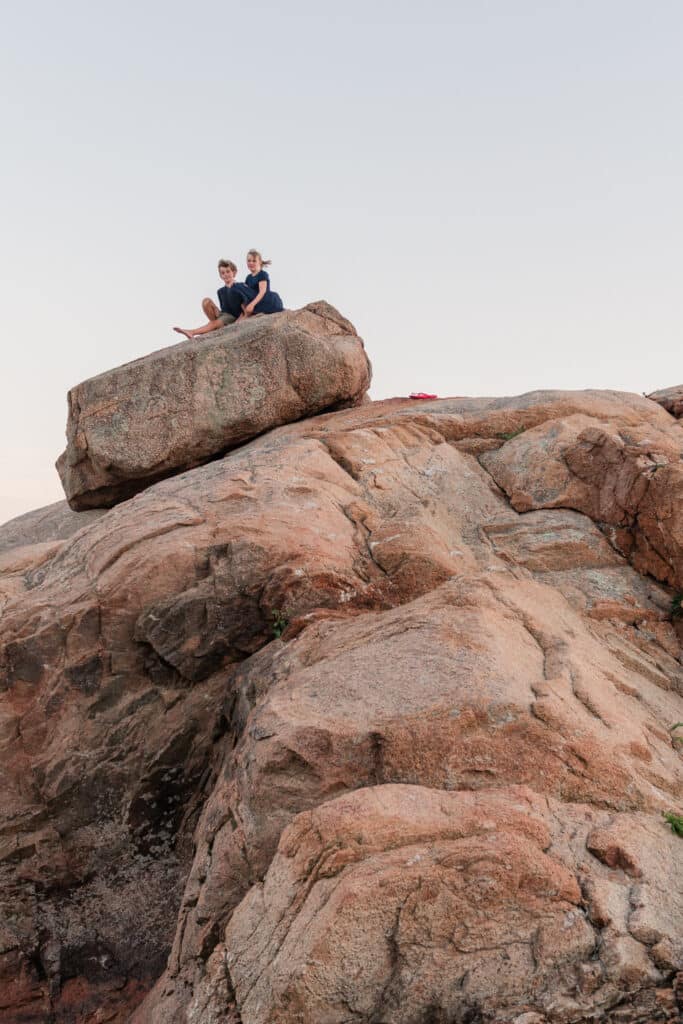 two children sit on a rock