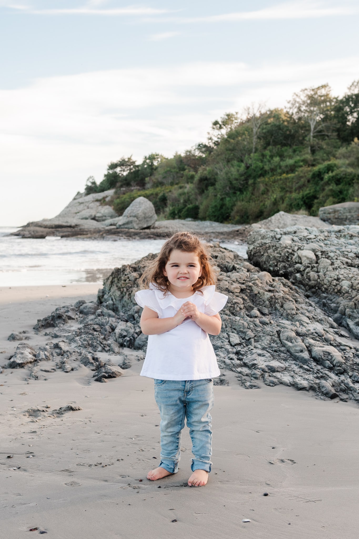 toddler girl smiles on beach