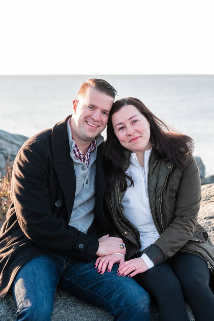 couple smiles near the ocean