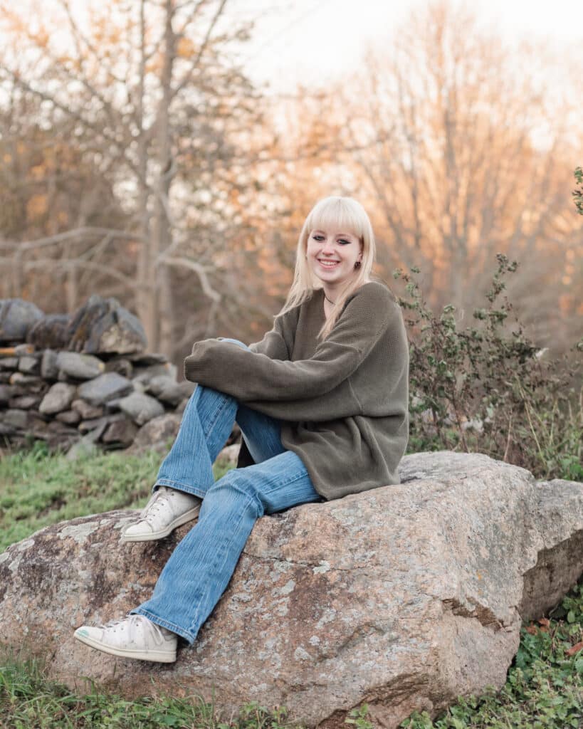 girl sits on rock at glen farm in portsmouth