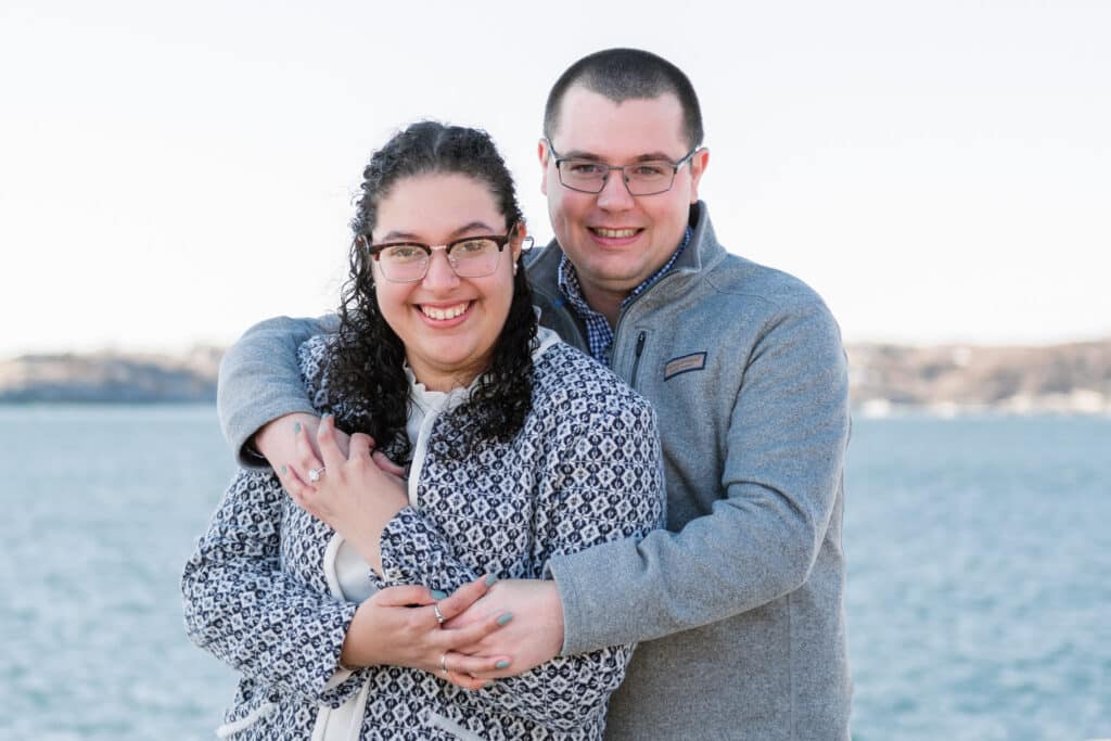 couple hugs after proposal at castle hill light