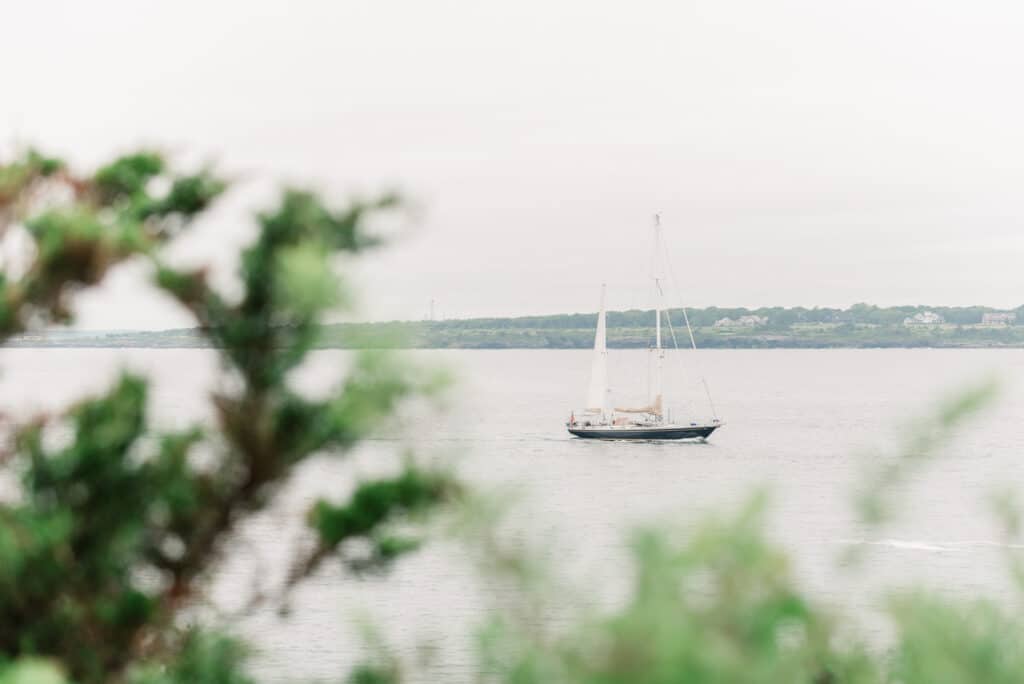 boat sails by castle hill in newport